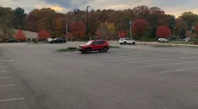 mostly empty parking lot with red SUV