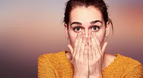 surprised woman with hands over her mouth