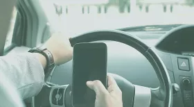 man using phone while driving as an example of negligent driving