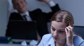 woman experiencing workplace bullying holding her hand in hand