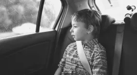 Child safely in car seat looking out window