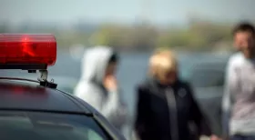 witnesses in background of police car after car accident