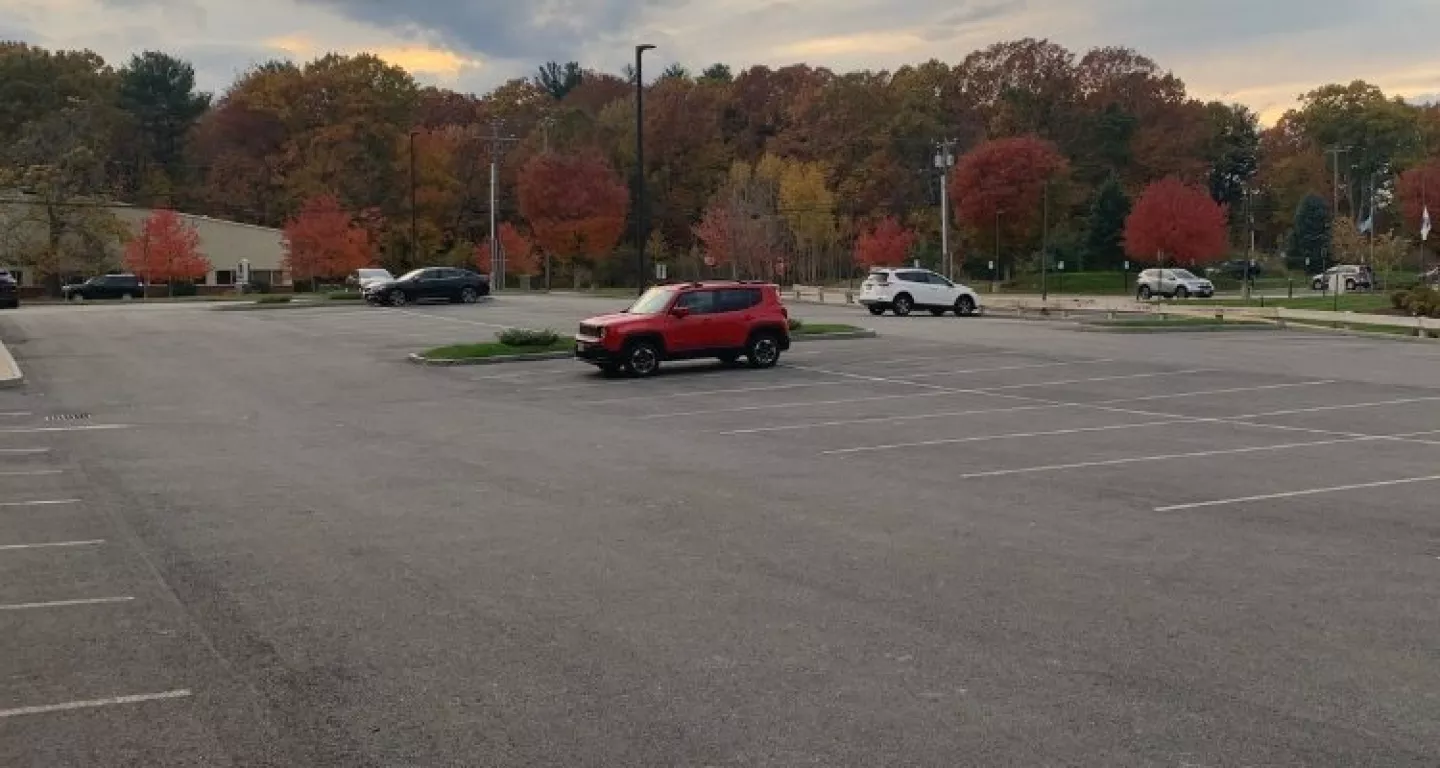mostly empty parking lot with red SUV