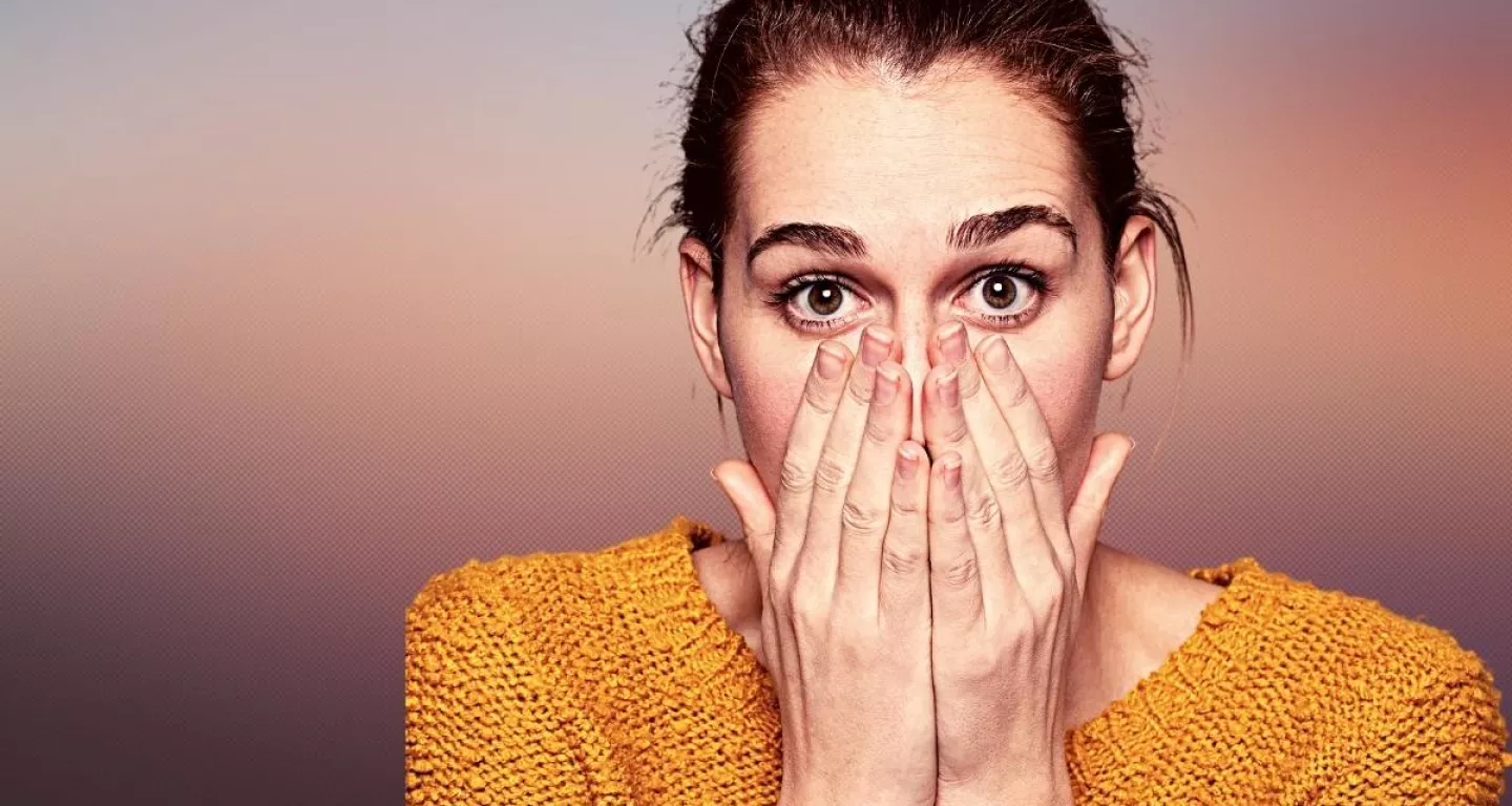 surprised woman with hands over her mouth