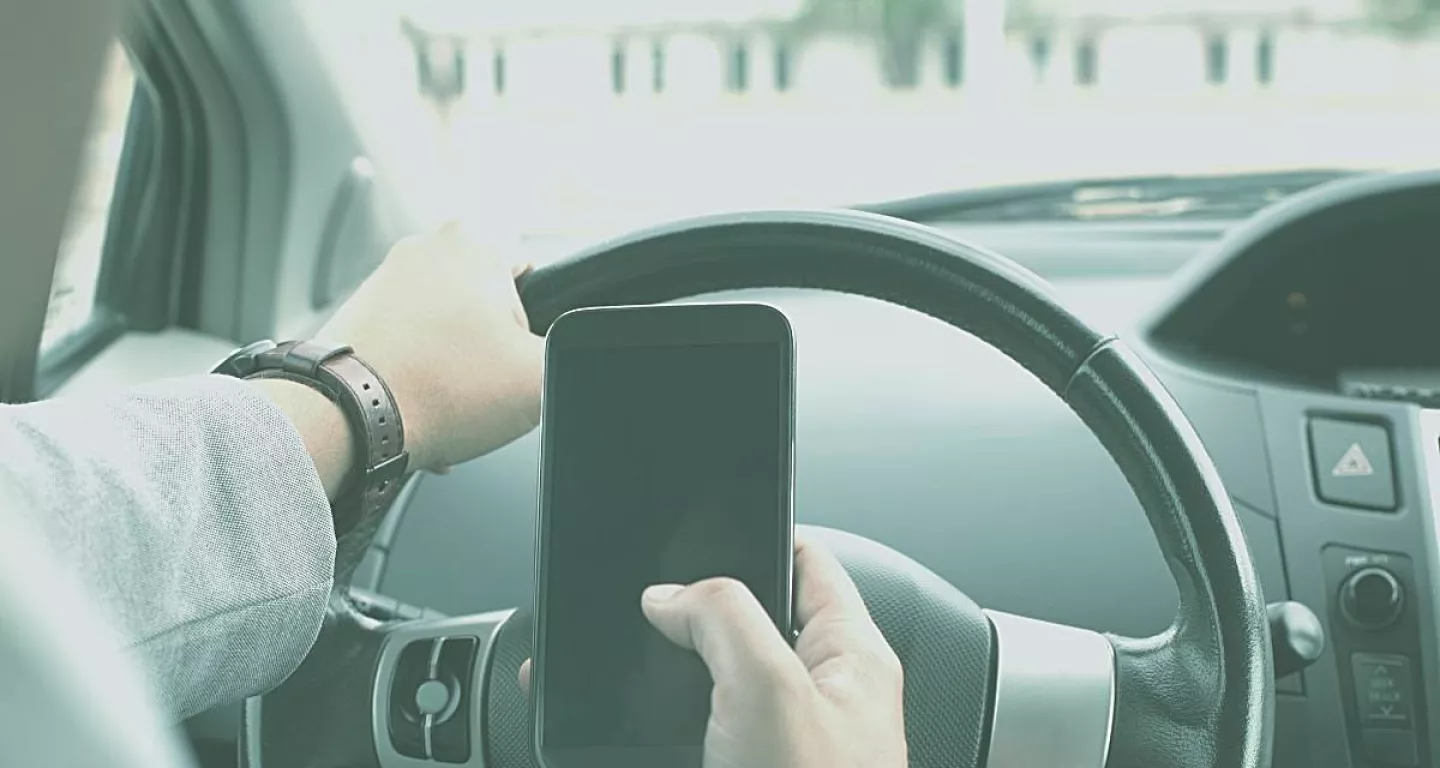 man using phone while driving as an example of negligent driving