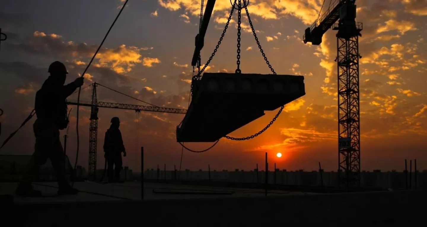 construction workers on site with cranes and scaffolding