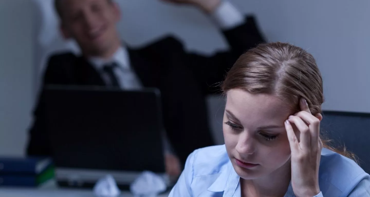 woman experiencing workplace bullying holding her hand in hand