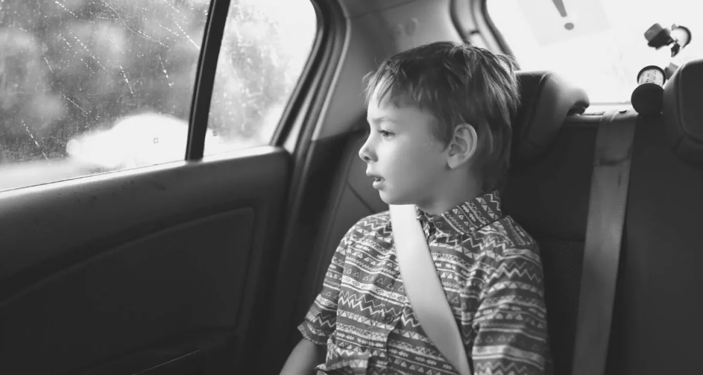 Child safely in car seat looking out window