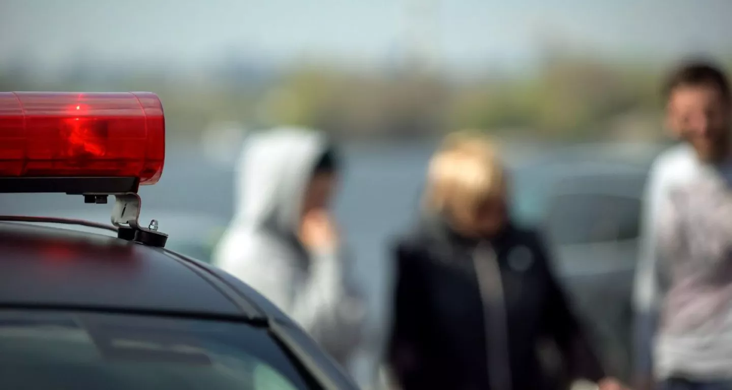 witnesses in background of police car after car accident